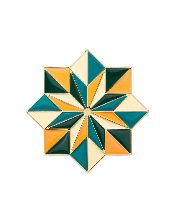 Kajal Kolada perfume cap close-up with gold star design and green, orange geometric enamel detailing