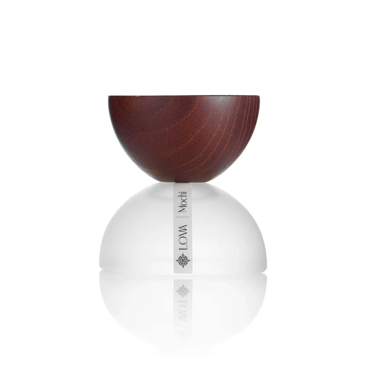 Lova Mochi niche perfume bottle with wooden cap and white rounded base on reflective surface