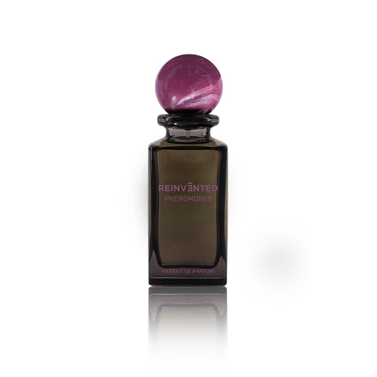 Pheromones by Reinvented Extrait de Parfum bottle with purple marble cap on white background