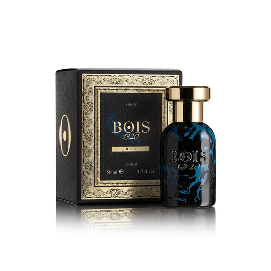 Luxury BOIS 1920 Rebus perfume bottle with blue marbled glass and gold cap, beside its black ornate box on white reflective surface.