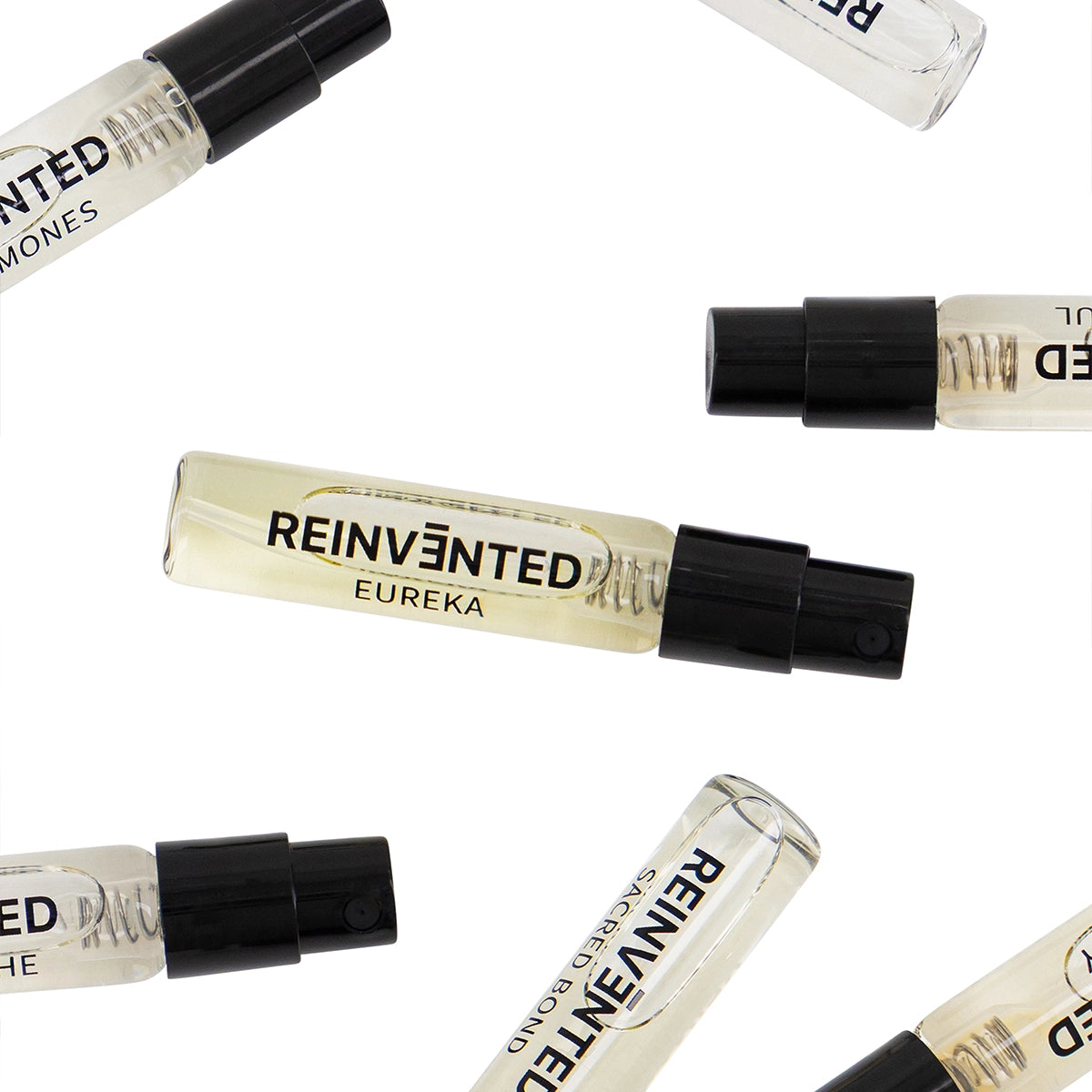 Reinvented Discovery Set scattered assortment of extrait perfume vials including Sacred Bond, Eureka, Illusion