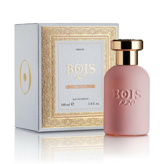 A pink perfume bottle with a gold cap, labeled 'BOIS 1920' and 'ORO ROSA', alongside its white packaging box with gold detailing.