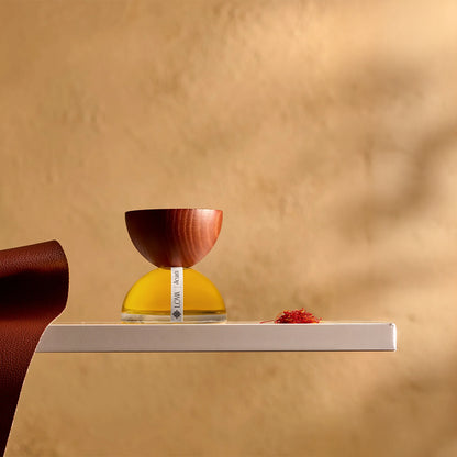 Acuada by LOVA niche perfume bottle with wooden cap placed on minimalist shelf against warm textured background