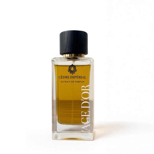 Cèdre Impérial by L’Âge d’Or luxury Extrait de Parfum bottle with golden liquid and black cap on white background
