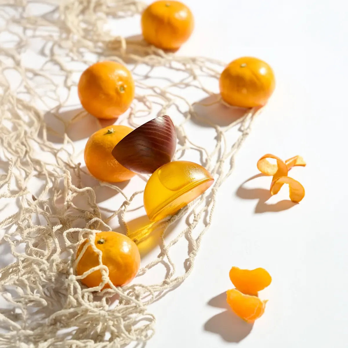 Cheerful Mandarin by LOVA niche fragrance bottle styled with fresh mandarins and citrus peels in bright natural light