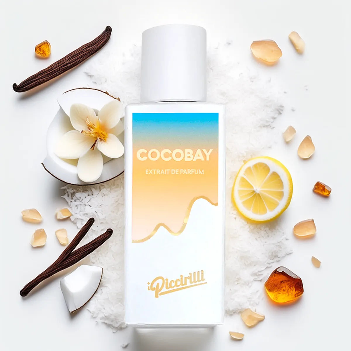 Cocobay extract de parfum bottle with vanilla beans, flowers, and lemon on a white background