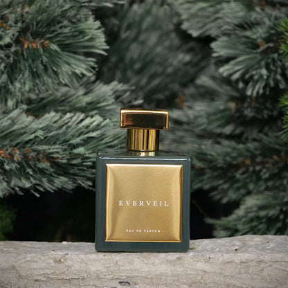 Everveil Eau de Parfum by House of Brandt luxury green and gold perfume bottle displayed outdoors with evergreen branches background