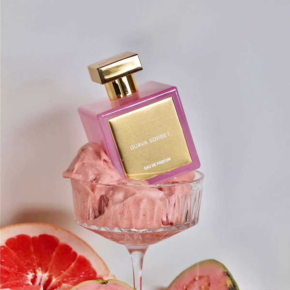 Guava Sorbet Eau de Parfum by House of Brandt pink perfume bottle styled with guava sorbet, grapefruit and fresh fruit, luxury summer fragrance lifestyle image