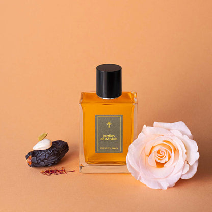 Une Nuit Nomade Jardins de Misfah Eau de Parfum bottle with date fruit, saffron threads, and rose flower, niche fragrance inspired by Arabian date gardens, warm gourmand sweetness, and oriental floral elegance