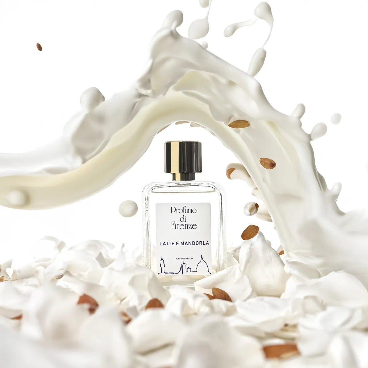 Perfume bottle labeled 'Profumo di Firenze' surrounded by a splash of milk and almonds on a white background