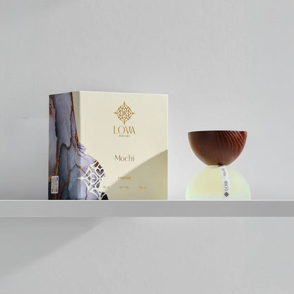 LOVA Mochi Parfum 50ml with frosted glass base and wooden cap displayed beside branded luxury box on minimalist white shelf
