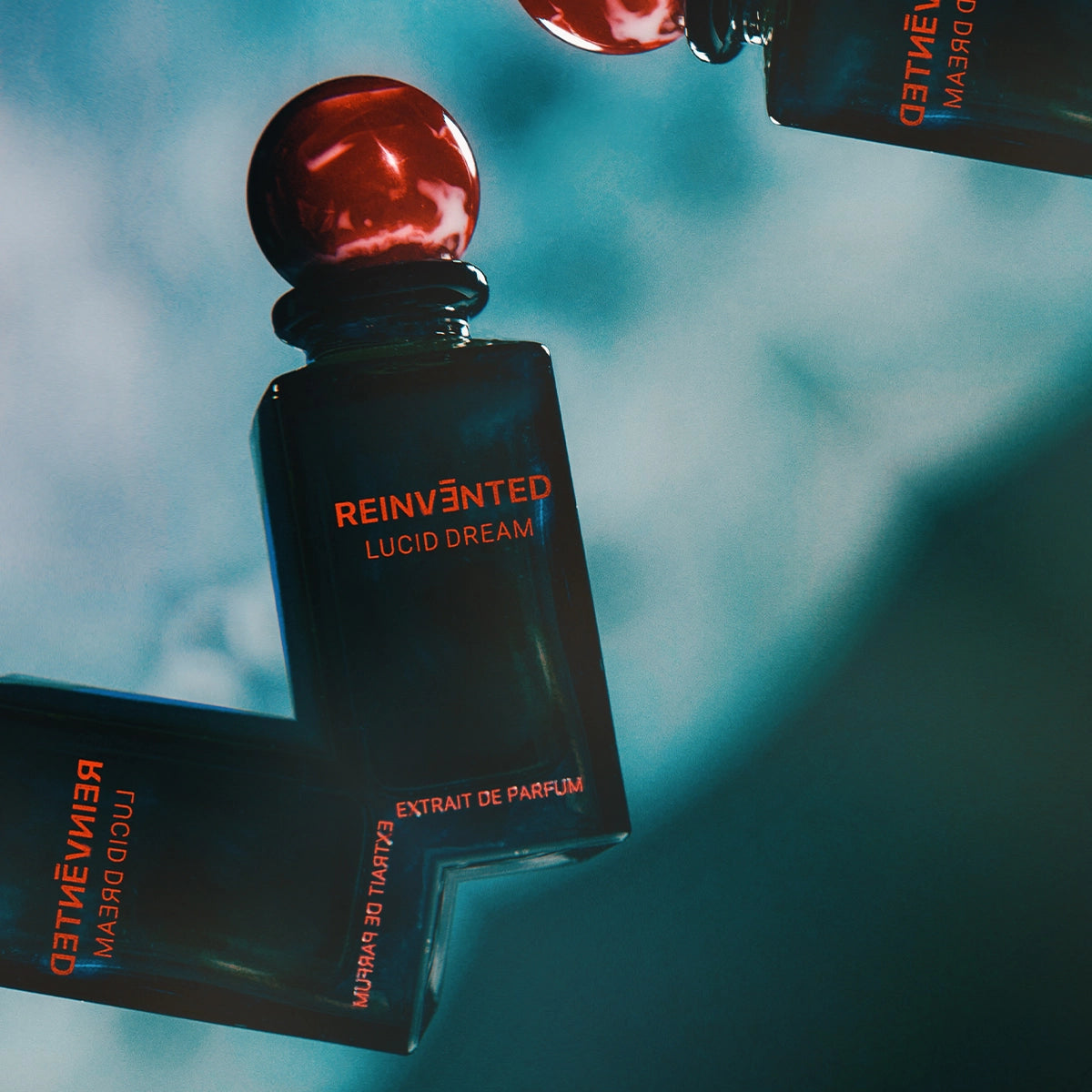 Reinvented Lucid Dream Extrait de Parfum artistic product shot with red marble cap luxury niche fragrance bottle
