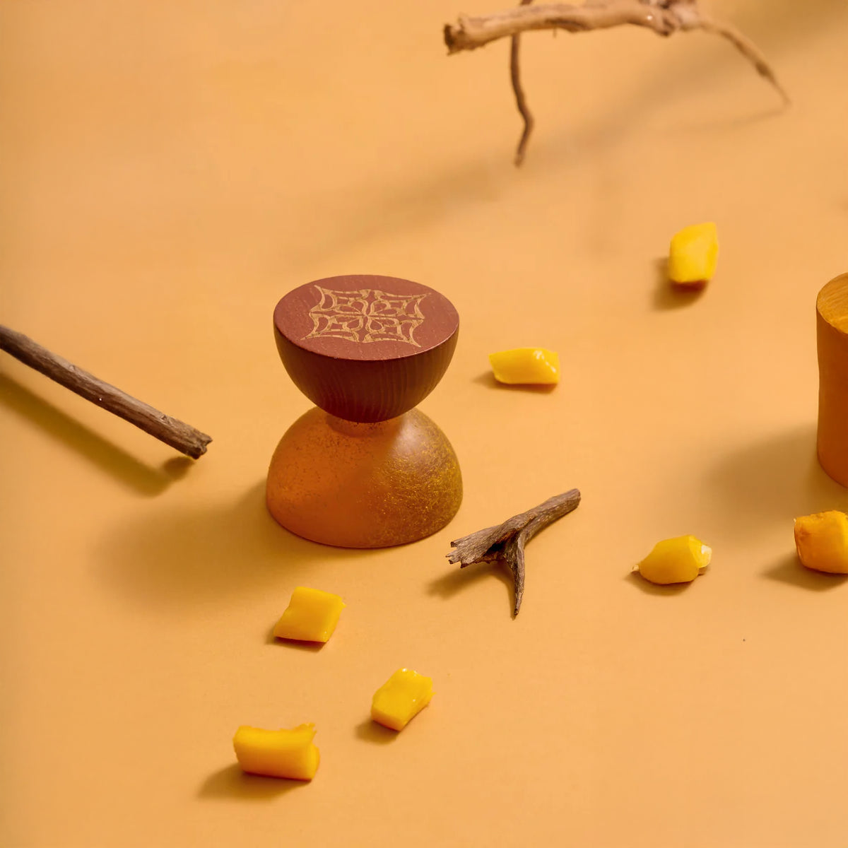 Mango Oud by LOVA luxury niche perfume with textured golden bottle and wooden cap styled with mango pieces and oud wood on warm background