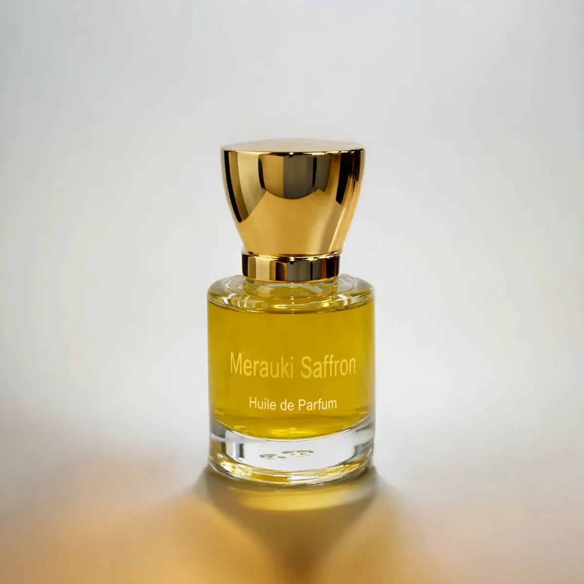 Merauki Saffron huile de parfum bottle with golden liquid and cap on soft neutral gradient background