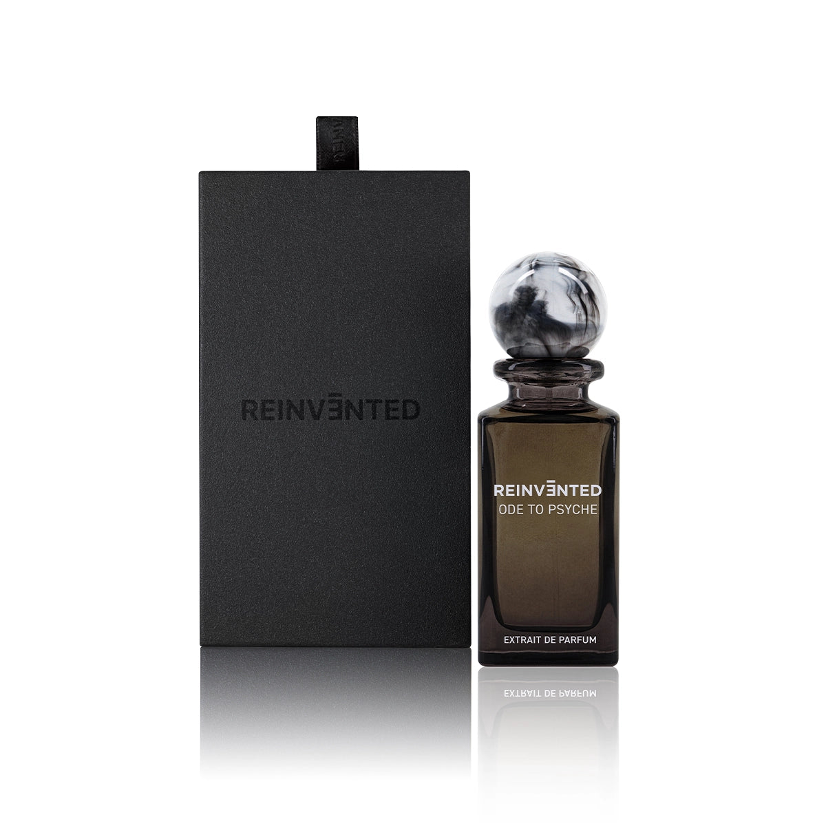 Ode to Psyche by Reinvented extrait de parfum with black box packaging and brown glass perfume bottle featuring marble cap on white background