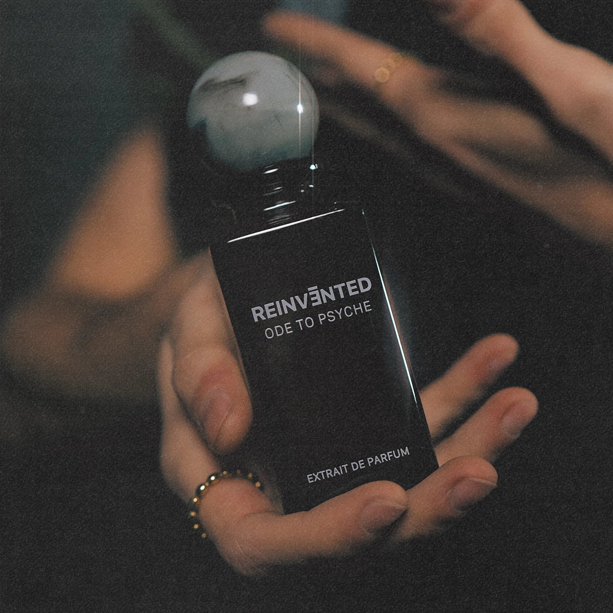 Reinvented Ode to Psyche extrait de parfum luxury niche fragrance bottle held in hand with marble cap close-up lifestyle shot