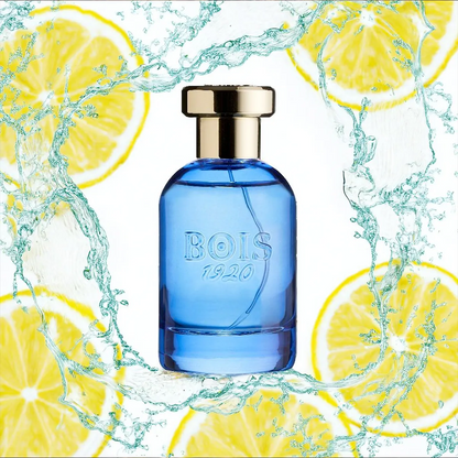 Bois 1920 Oltremare Eau de Parfum blue glass bottle with gold cap surrounded by splashing water and fresh lemon slices, evoking a vibrant citrus aquatic fragrance