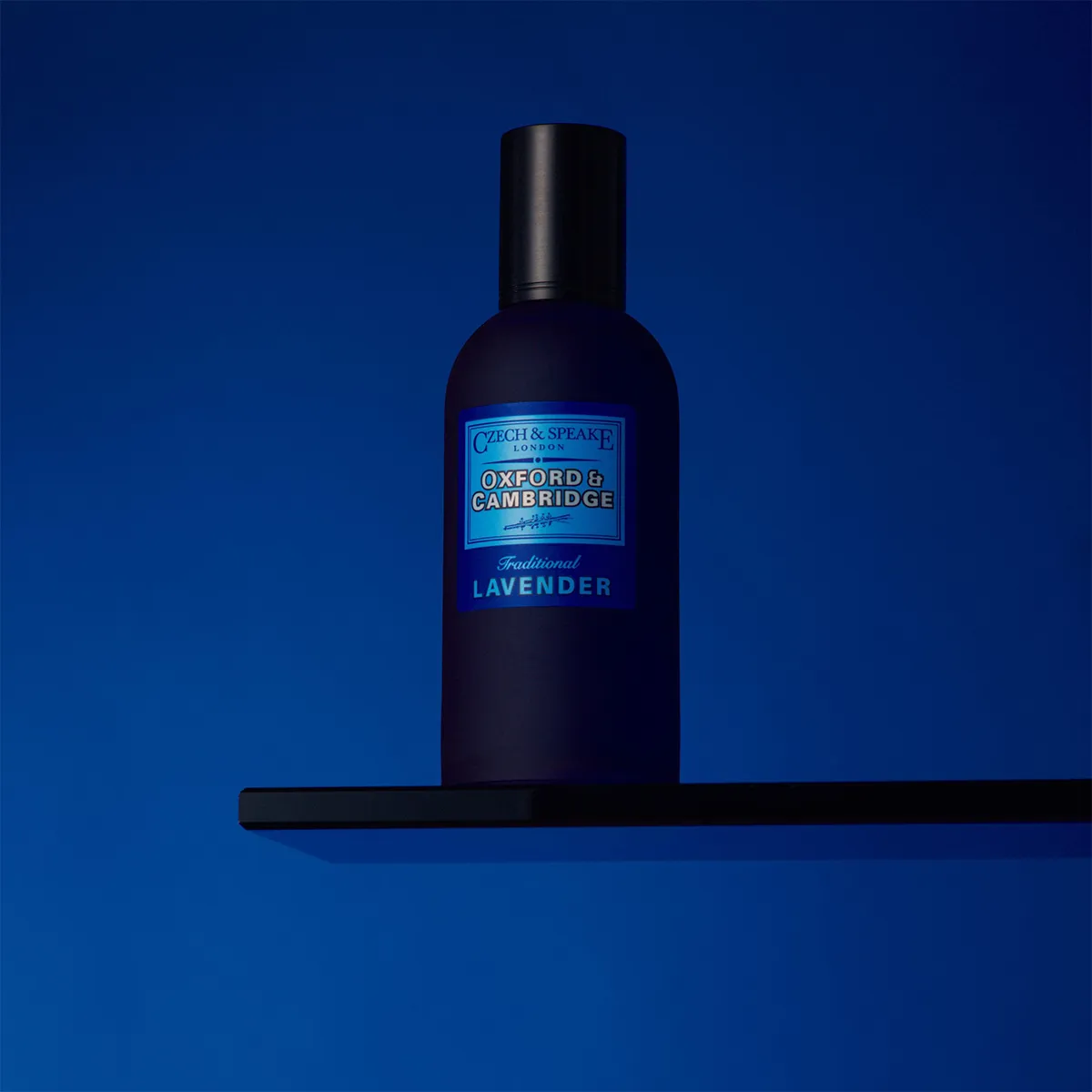 Czech & Speake Oxford & Cambridge Traditional Lavender Eau de Parfum deep blue fragrance bottle displayed on a minimalist shelf, classic British perfume inspired by fresh lavender and aromatic herbal notes