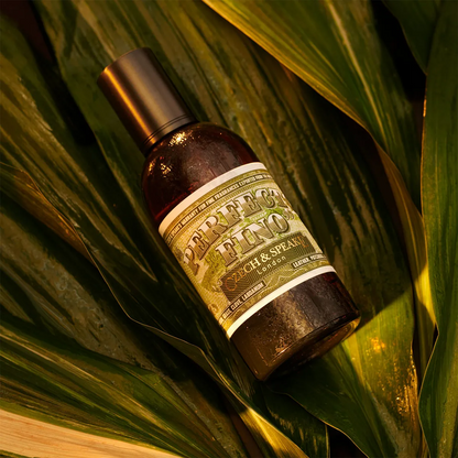 Czech & Speake Perfecto Fino perfume bottle placed on lush green leaves, luxury niche fragrance from London featuring rich notes of leather, patchouli, labdanum, and clove