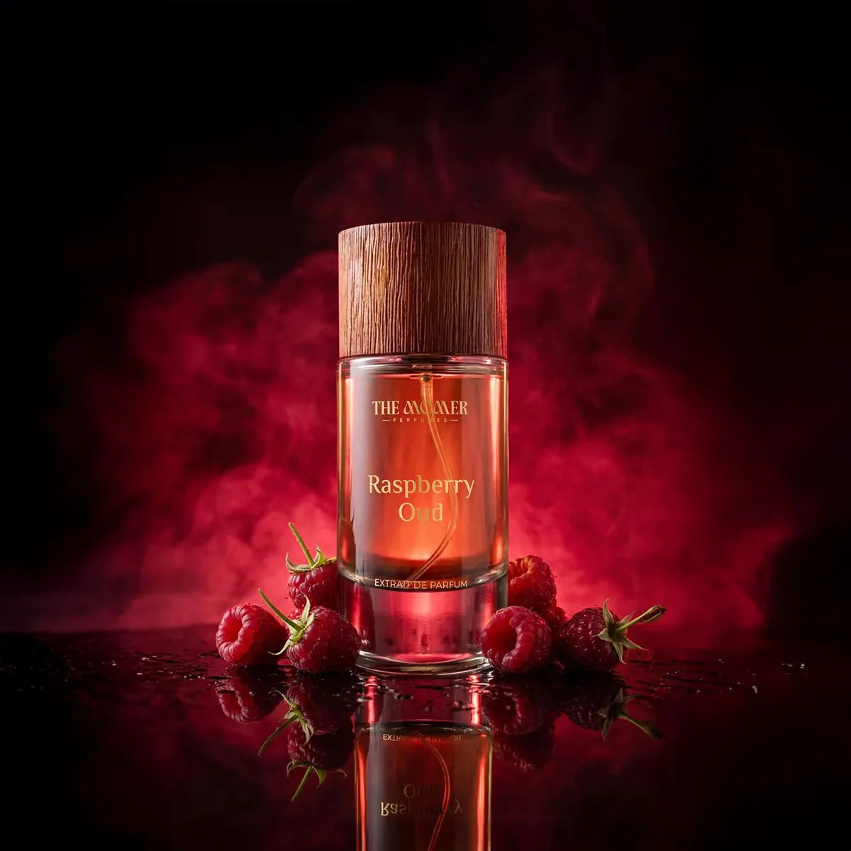 The Momer Raspberry Oud Extrait de Parfum luxury fragrance bottle with wooden cap surrounded by fresh raspberries in dramatic red smoky background