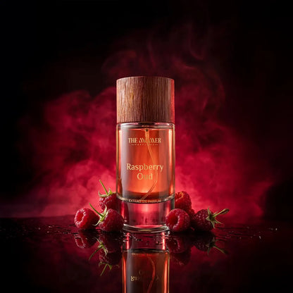 The Momer Raspberry Oud Extrait de Parfum luxury fragrance bottle with wooden cap surrounded by fresh raspberries in dramatic red smoky background