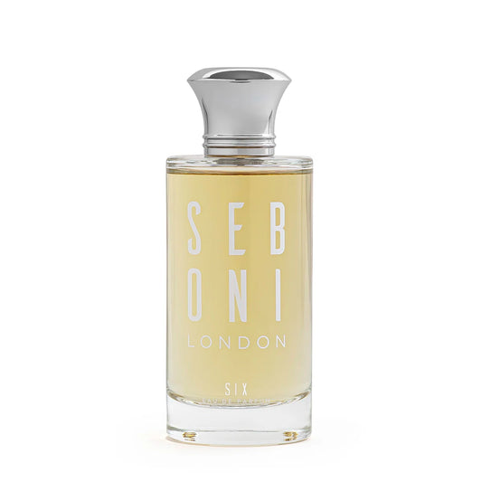 Seboni London Six Eau de Parfum in a clear glass bottle with soft amber liquid and a polished silver cap on a minimal white background