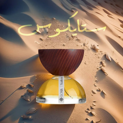 Staikous by LOVA luxury parfum bottle with golden glass base and wooden cap set on desert sand background with warm sunset lighting