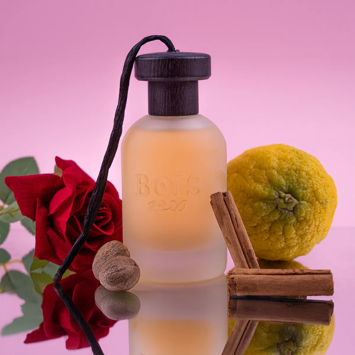 Bois 1920 Sushi Imperiale perfume bottle with frosted glass surrounded by rose, citrus fruit, cinnamon sticks, vanilla pod and nutmeg.