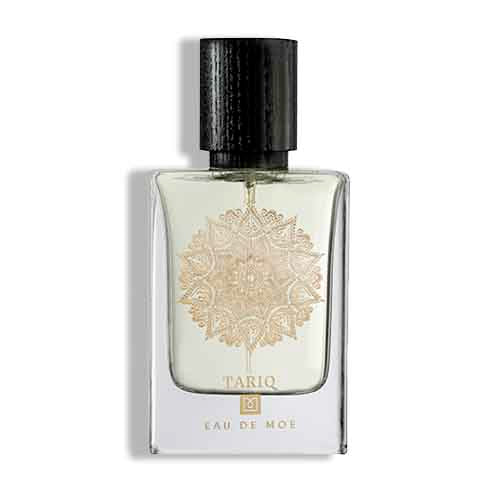 Tariq Eau De Moe perfume bottle with textured black cap and gold mandala emblem on clear glass flacon